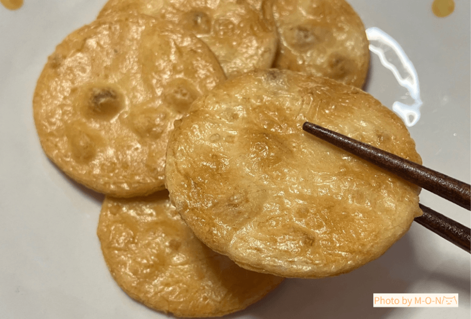 味泉のみちのく小丸せんべいしょうゆを箸でつかんだところ