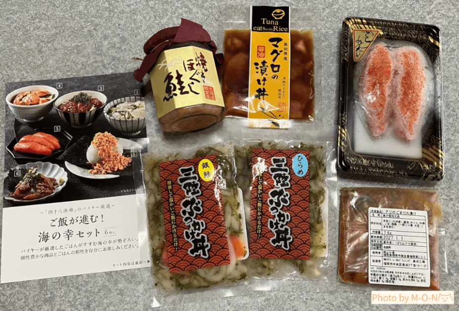 APホールディングス優待の水産品セットに同封されている『ご飯が進む!海の幸セット』の説明紙と、6品を机に並べた全体写真が一緒に写っている様子